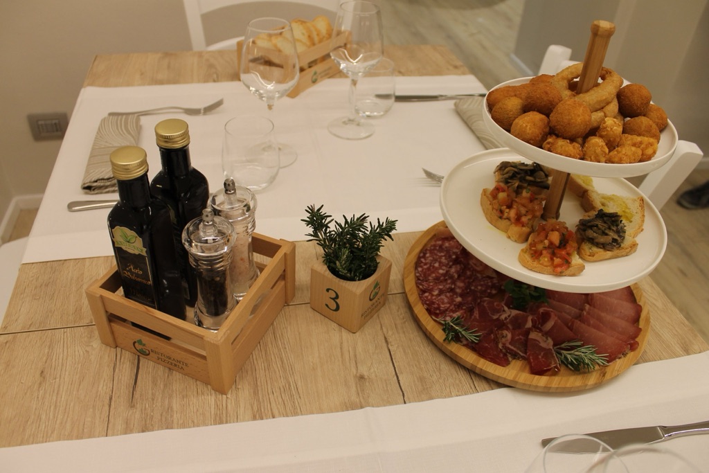 Tavola con olio e antipasti al ristorante del villaggio