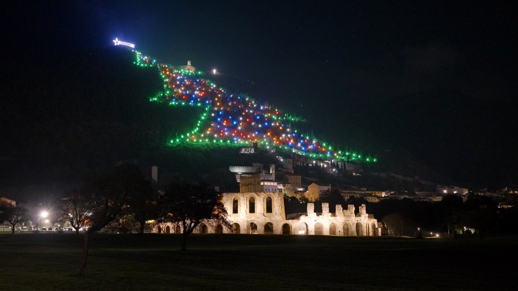 L'albero di luci sul Monte Ingino sopra Gubbio e il teatro romano illuminato, di notte