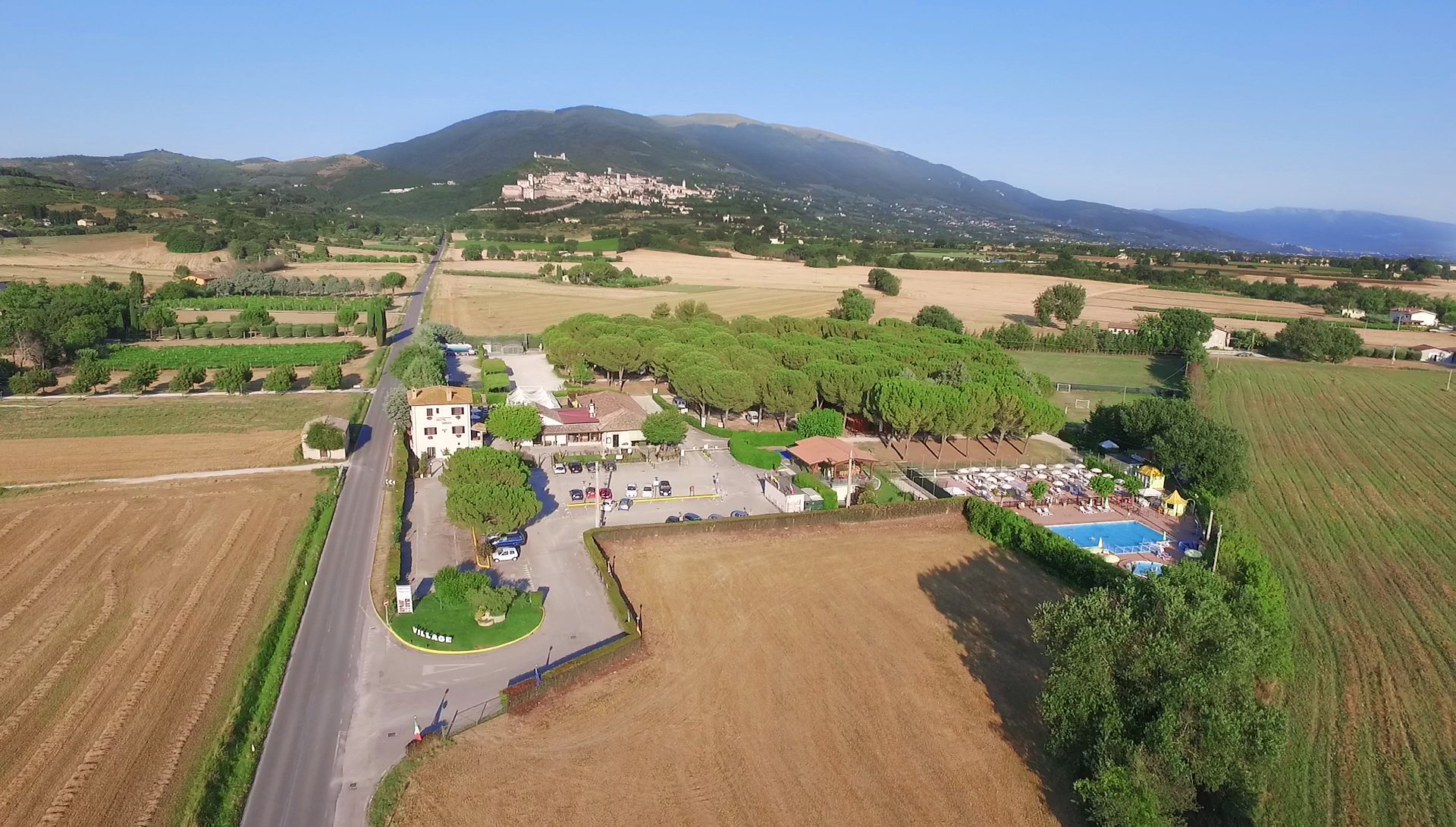 Il villaggio e, sullo sfondo, Assisi, visti dal drone